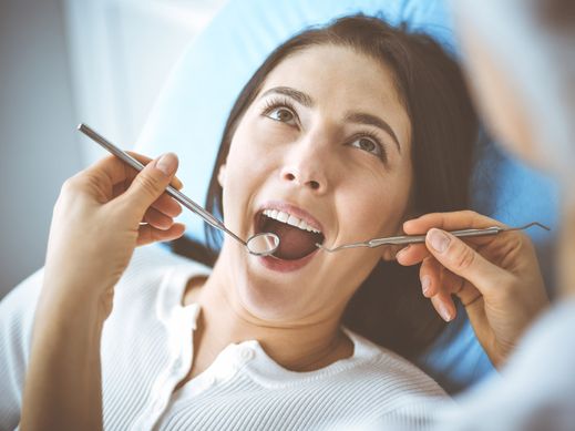 Dentista explorando boca de paciente
